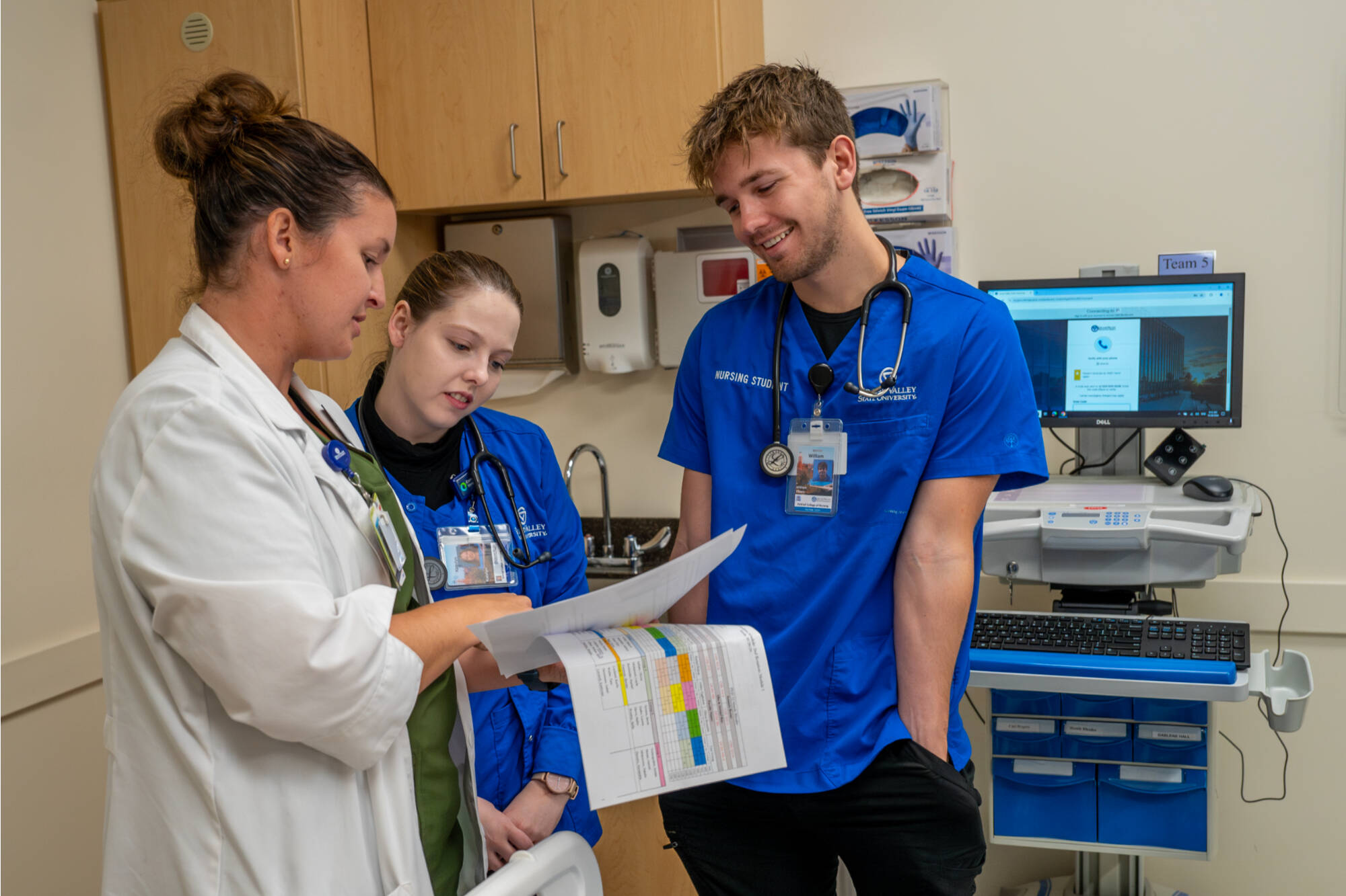 Nursing students and instructor having a teaching and learning discussion in the simulation center.